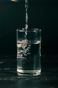 verre eau qui coule fond sombre